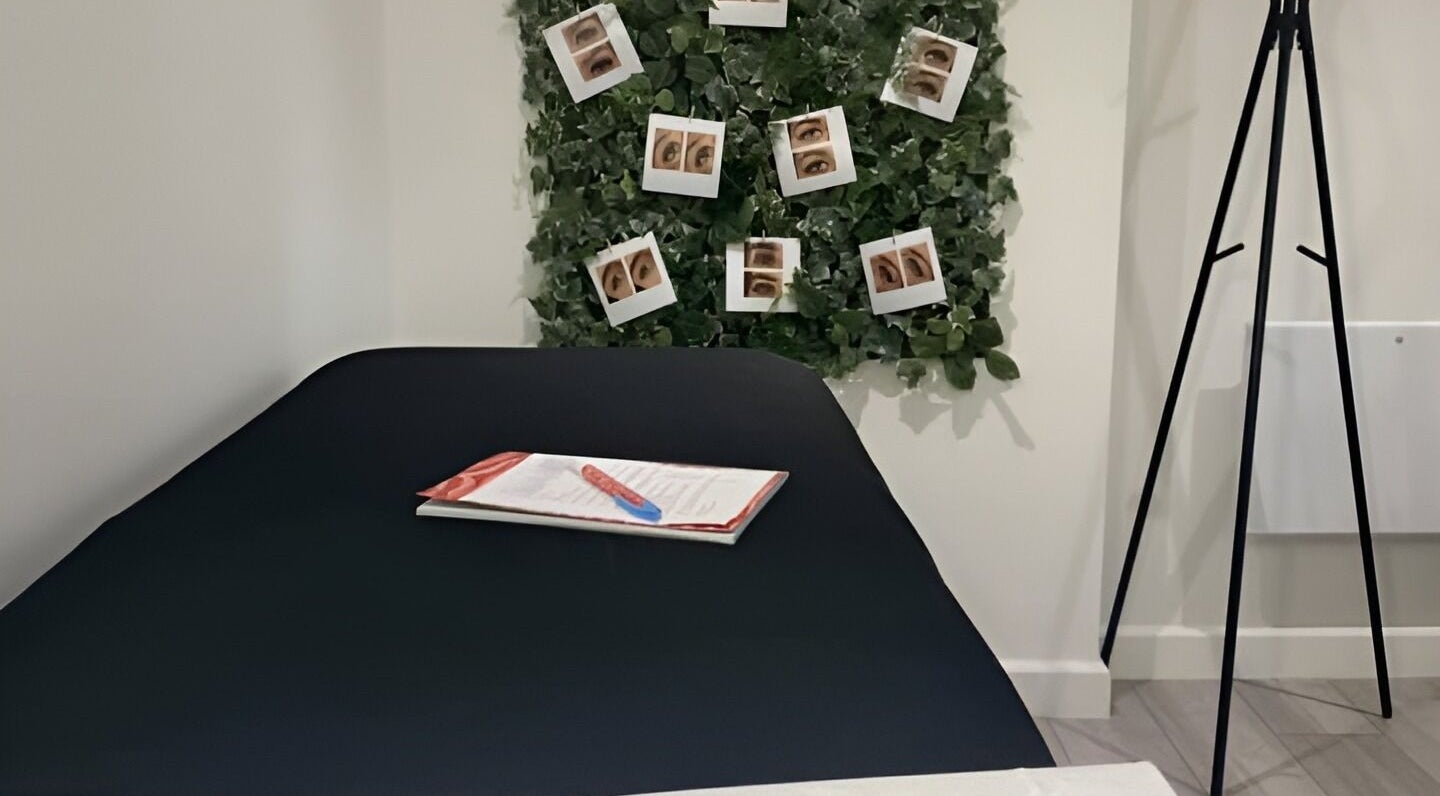 Calm treatment room at Lashes by Georgina in Andover, England, GB, showcasing a bed and green decor.