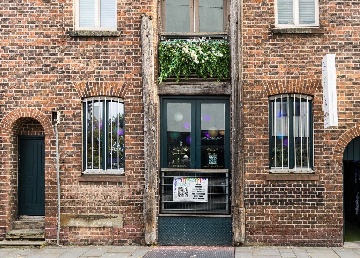 Front view of Metamorph Haus in Liverpool, England, GB, showcasing a charming brick facade with floral decoration.