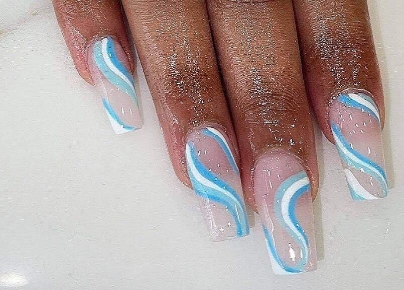 Elegant blue and white swirl nails at Ongles McGill, Montréal, Québec, CA, showcasing expert nail art design.