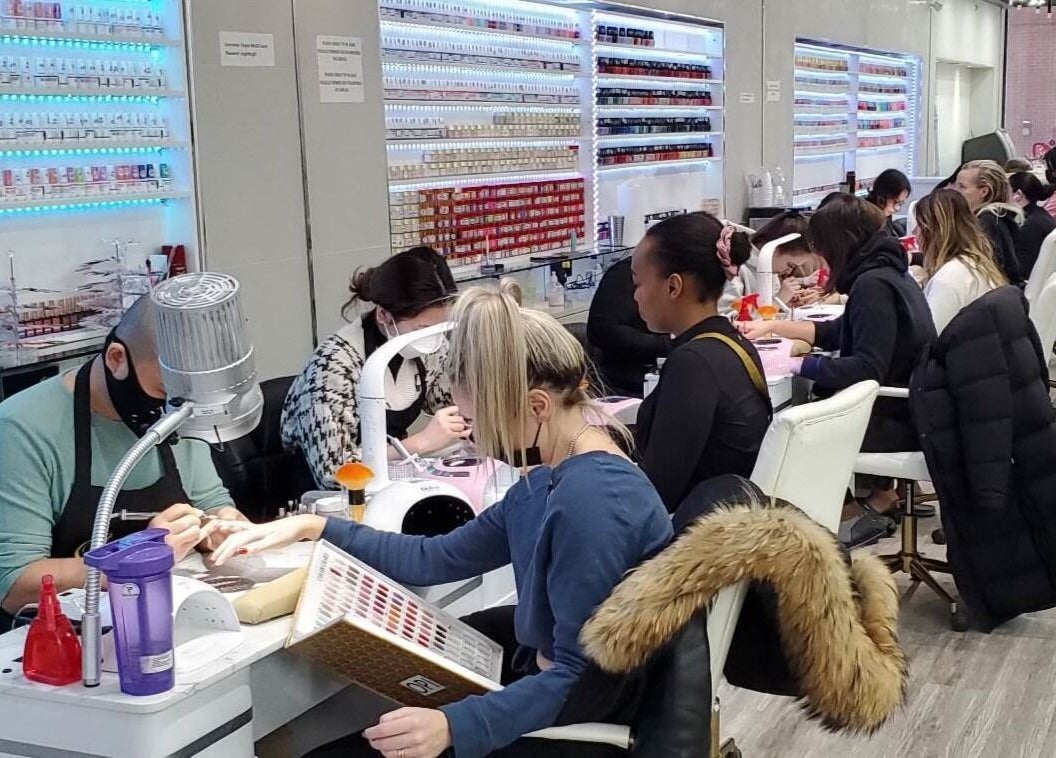 Clients enjoying manicure services at Ongles McGill in Montréal, Québec, CA, showcasing vibrant nail polish choices.