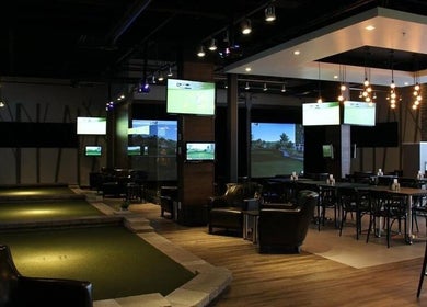 Intérieur moderne de Golf in Brossard, Brossard, Québec, CA avec écrans et éclairage élégant.