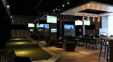 Intérieur moderne de Golf in Brossard, Brossard, Québec, CA avec écrans et éclairage élégant.
