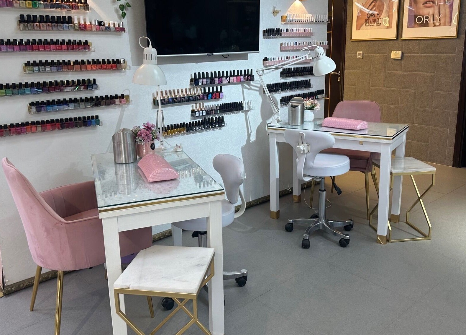 Chic nail studio at Juan Salon, Dubai, AE features elegant chairs, nail polish display, and modern lighting.