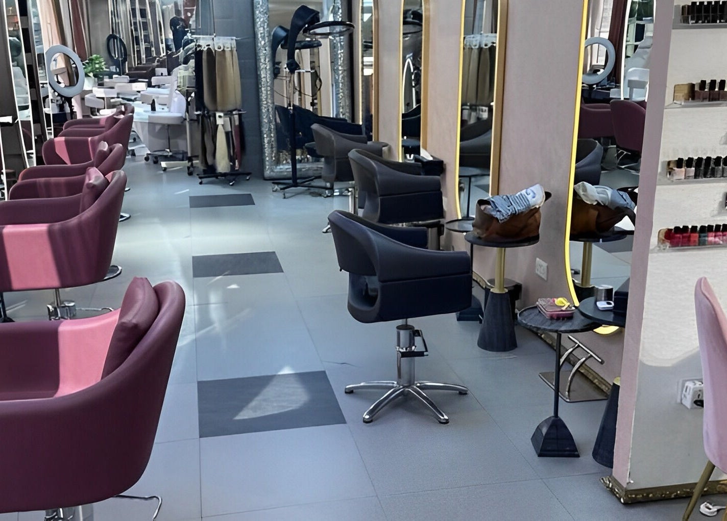 Modern salon interior at Juan Salon, Dubai, AE with stylish chairs and vibrant nail colors on display.