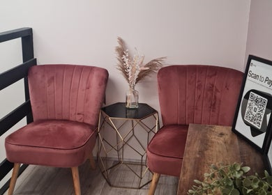 Elegant seating area at Glow & Co. | Brows And Beauty, Wallingford, England, GB with plush chairs and a decorative vase.