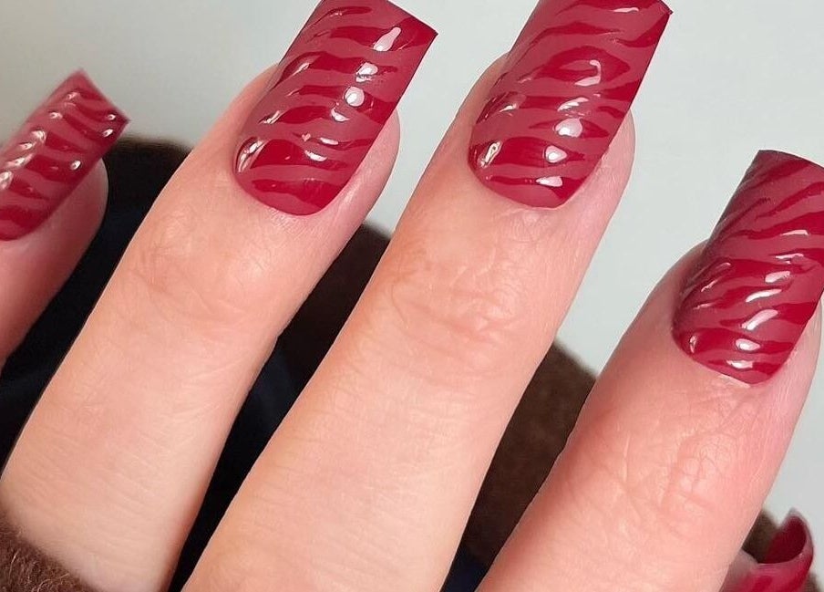 Stylish red zebra-patterned nails at Whitehead & Booth Salon & Permanent Jewellery, Sheffield, England, GB.