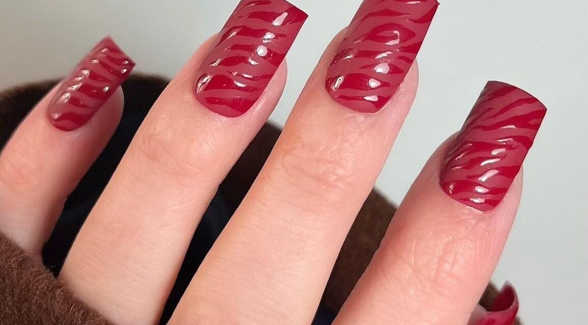 Stylish red zebra-patterned nails at Whitehead & Booth Salon & Permanent Jewellery, Sheffield, England, GB.