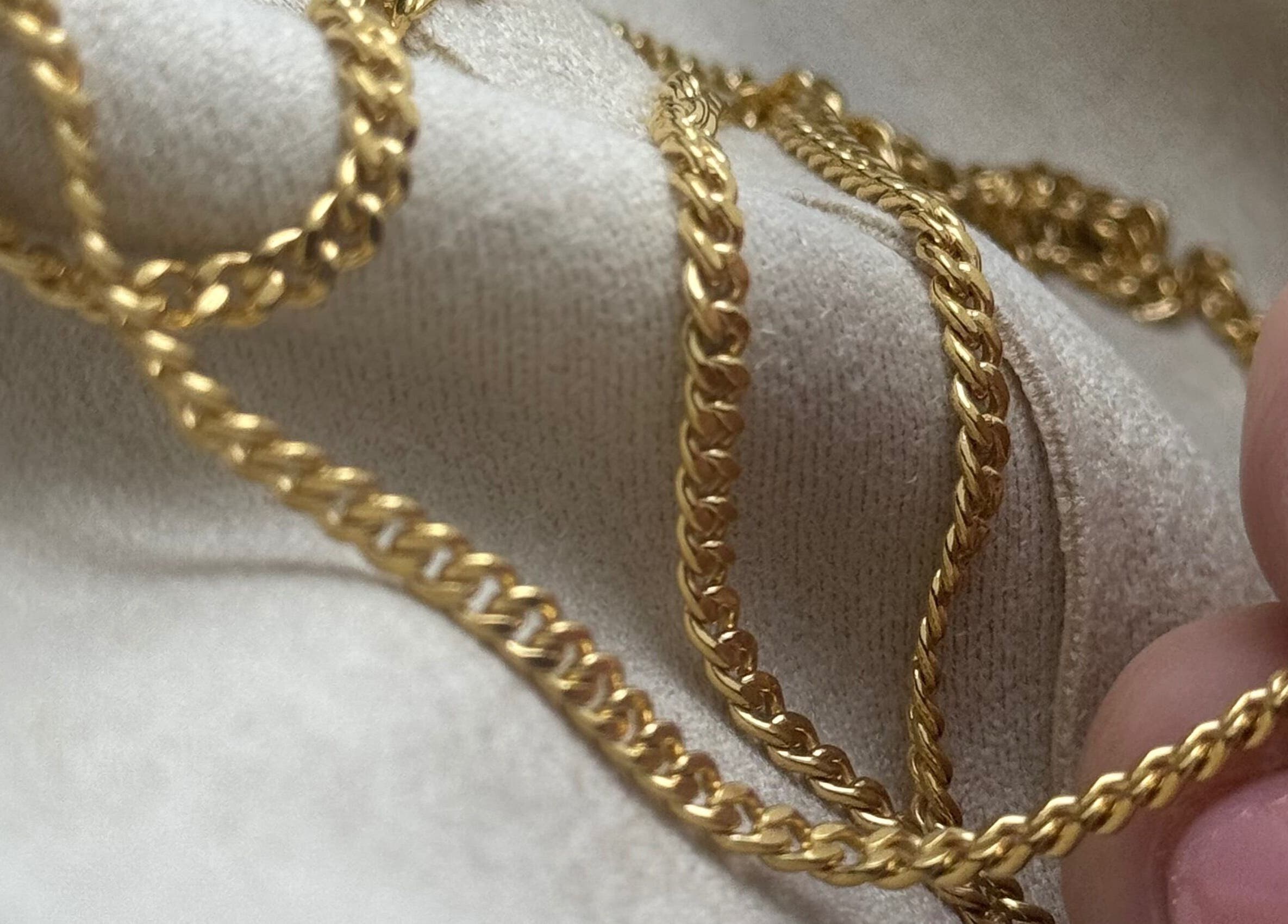 Close-up of a gold chain at Whitehead & Booth Salon & Permanent Jewellery, Sheffield, England, GB.