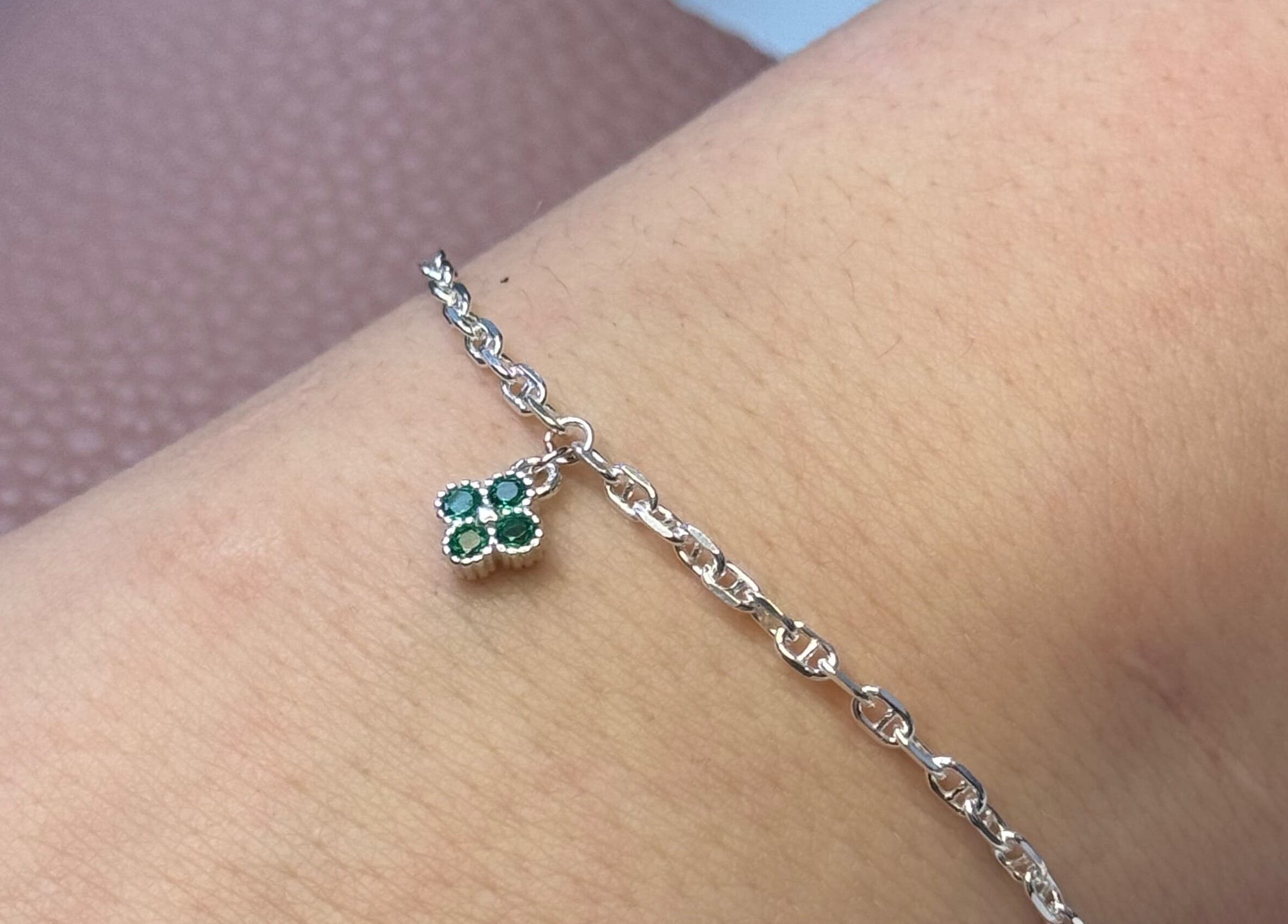 Delicate silver bracelet with emerald charm at Whitehead & Booth Salon & Permanent Jewellery, Sheffield, England, GB.