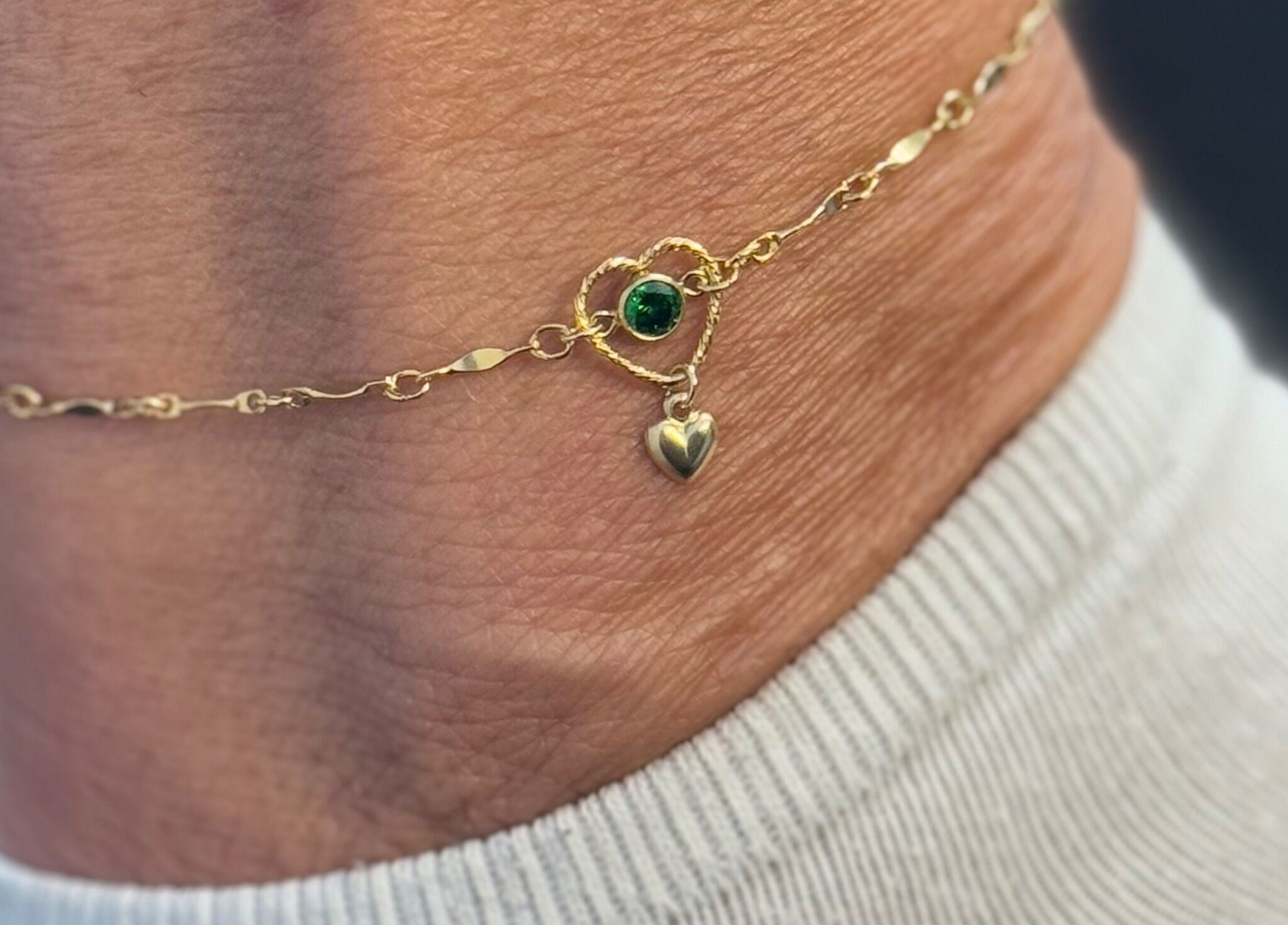 Elegant golden anklet with heart charm at Whitehead & Booth Salon & Permanent Jewellery, Sheffield, England, GB.
