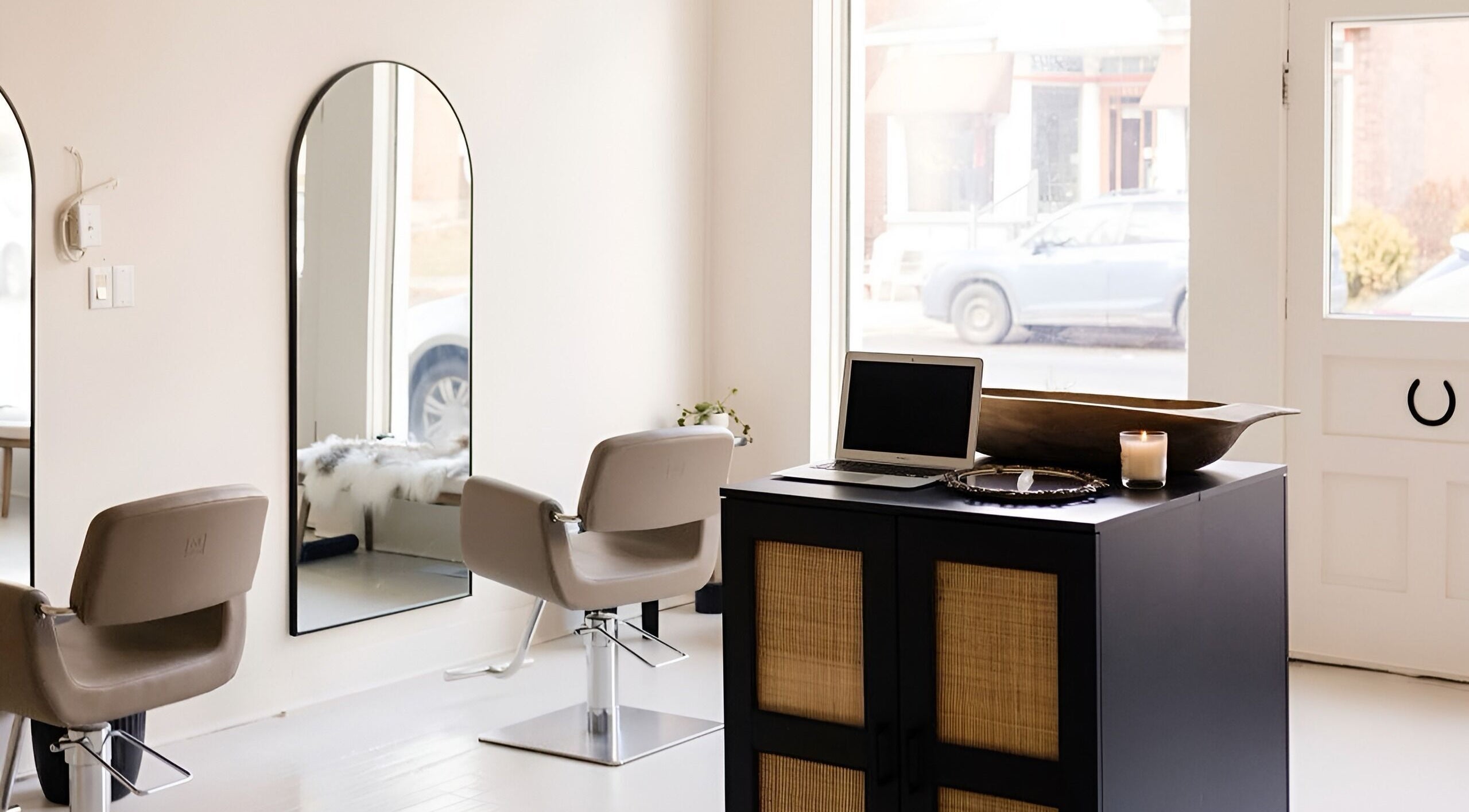 Modern interior of Odette Hair Studio, Prince Edward, Ontario, CA featuring stylish mirrors and chic seating.