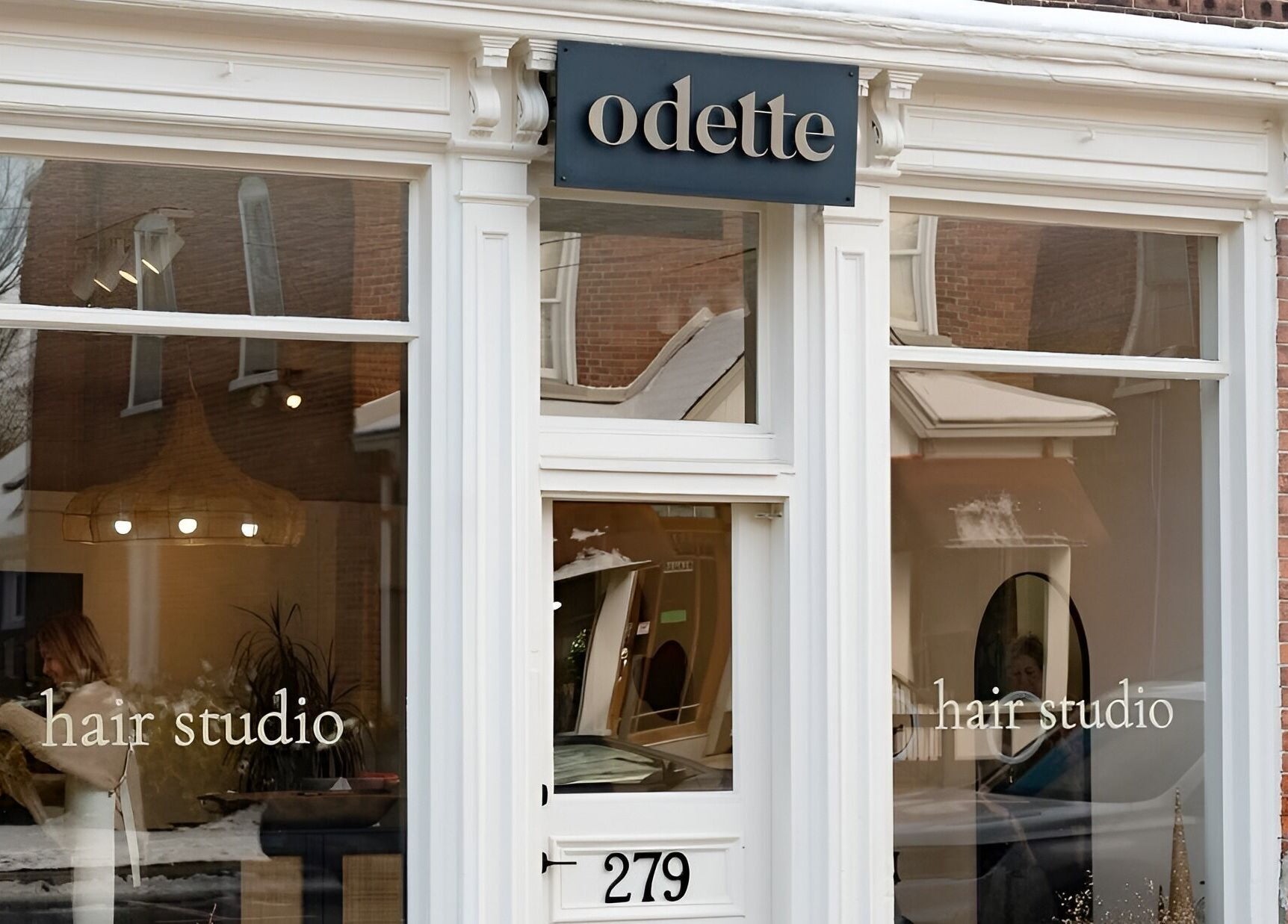 Front view of Odette Hair Studio located at Prince Edward, Ontario, CA with stylish large windows.