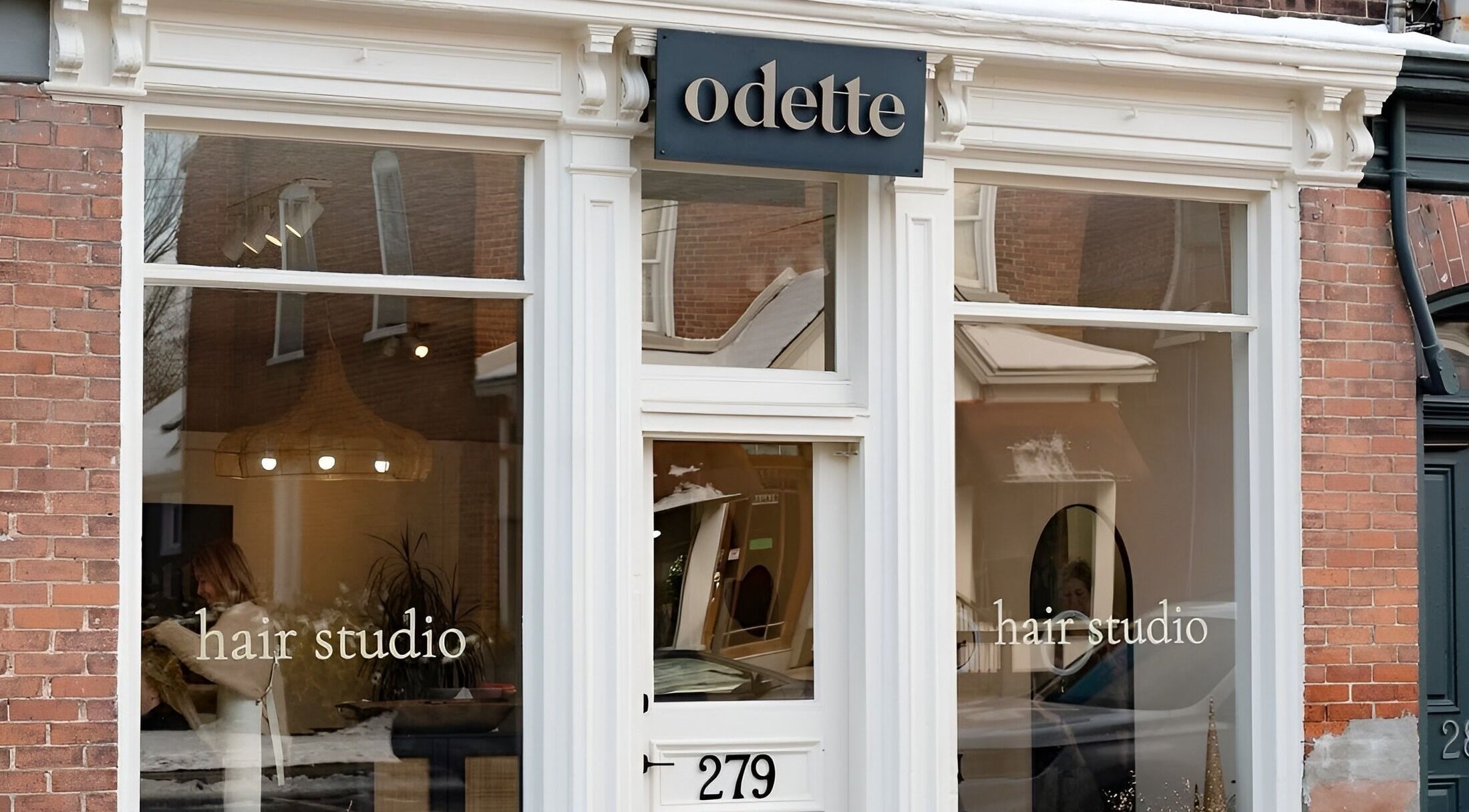 Front view of Odette Hair Studio located at Prince Edward, Ontario, CA with stylish large windows.