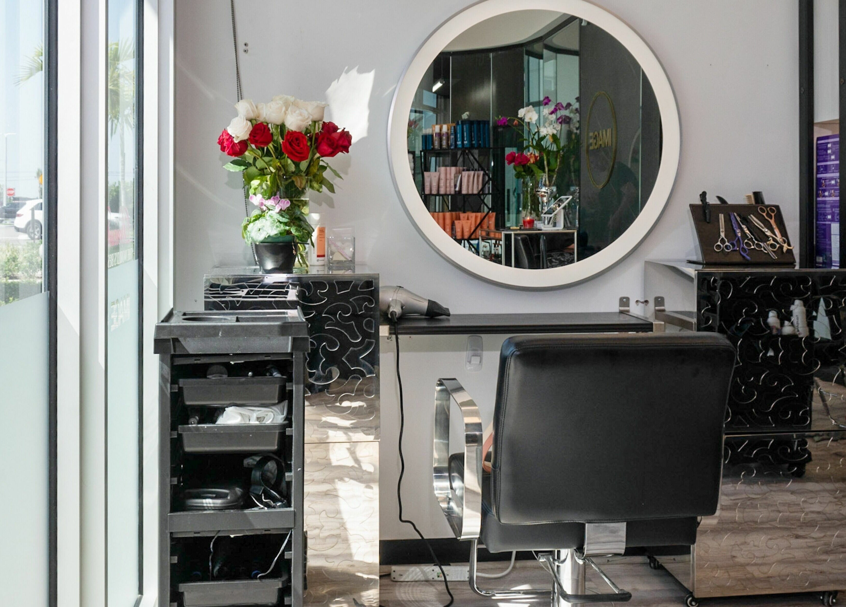 Stylish salon station at Jennifer The Hairstylist in Delray Beach, Florida, US with mirror and flowers.