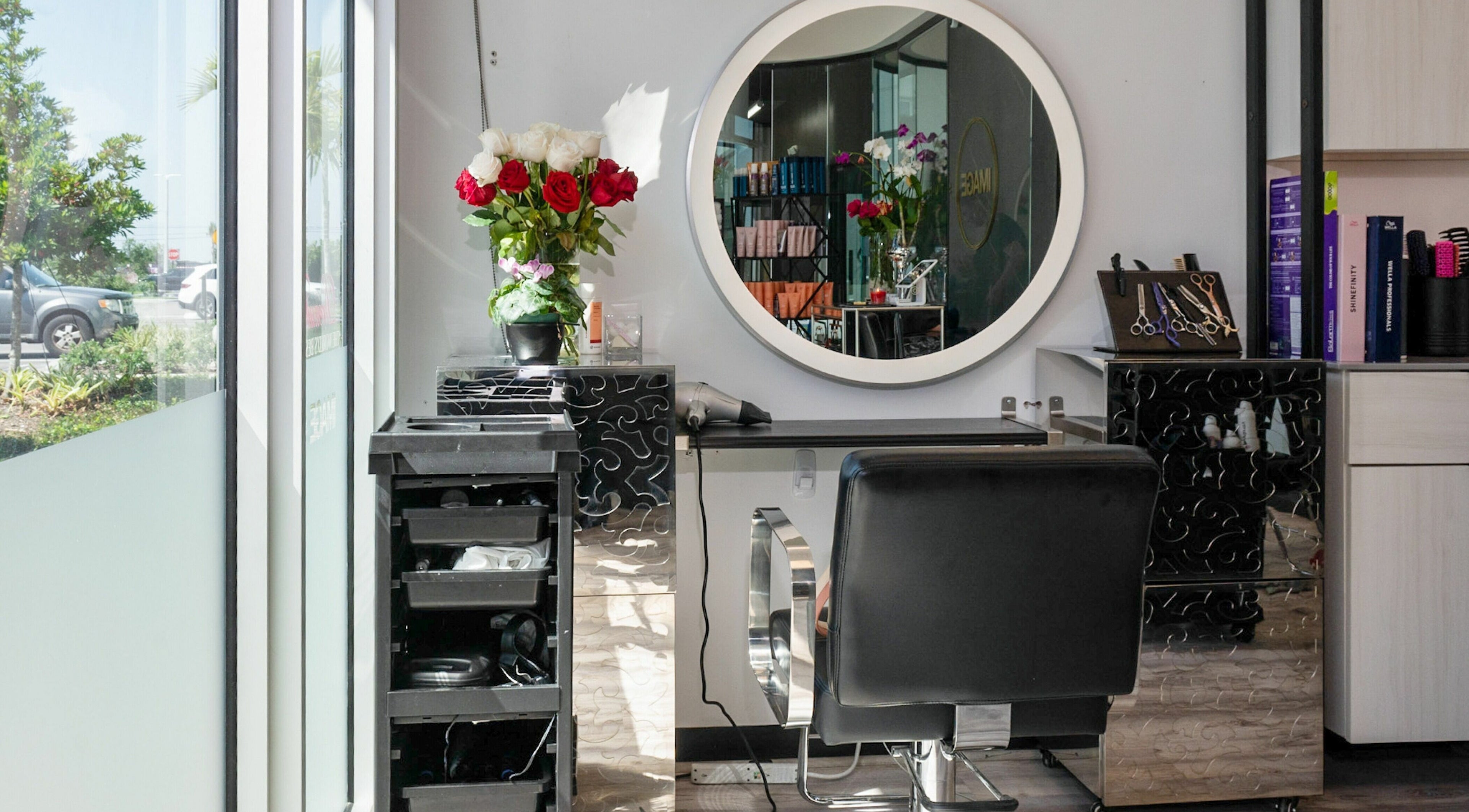 Stylish salon station at Jennifer The Hairstylist in Delray Beach, Florida, US with mirror and flowers.