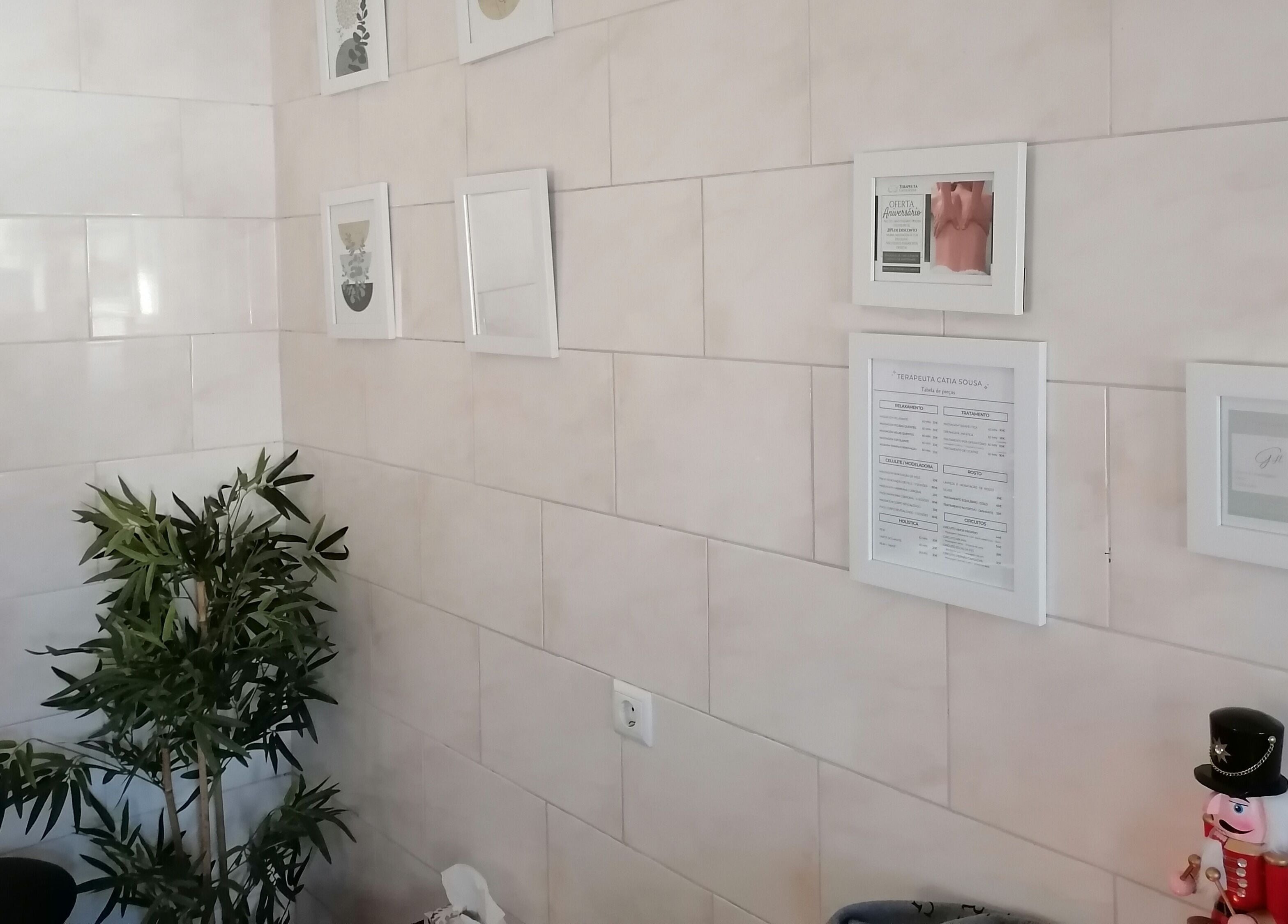 Parede decorada com quadros e planta em Terapeuta Cátia Sousa, Gondomar, Porto, PT.