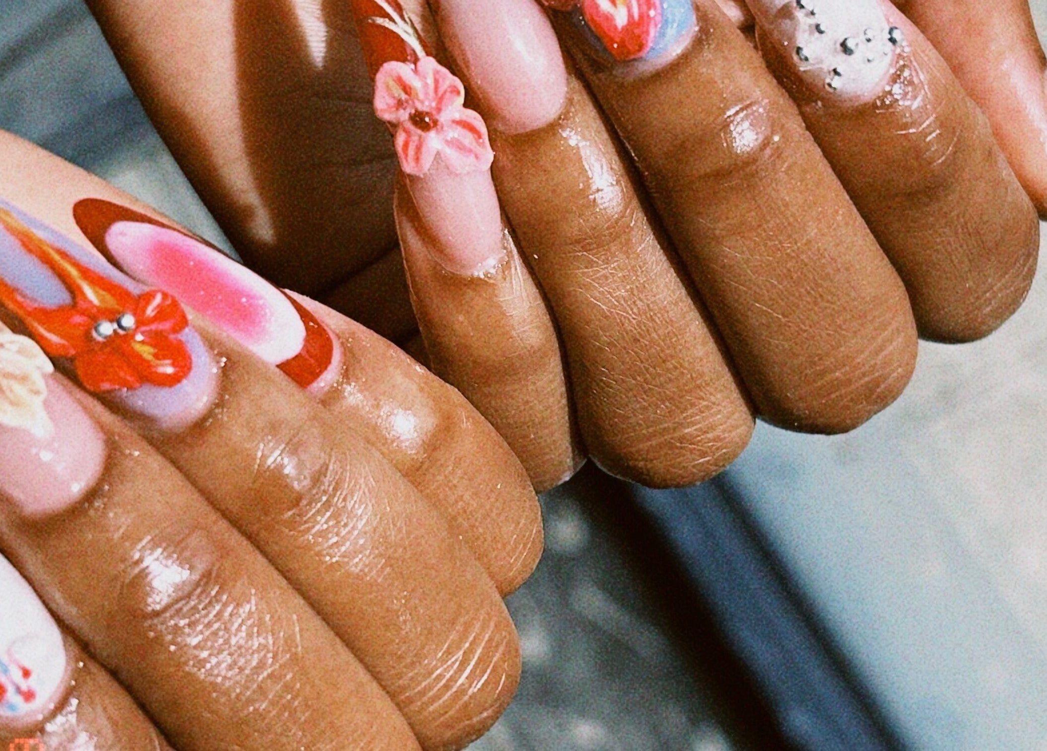 Vibrant floral nail art at Kayla the Brand, Manchester, England, GB, showcasing intricate 3D details.
