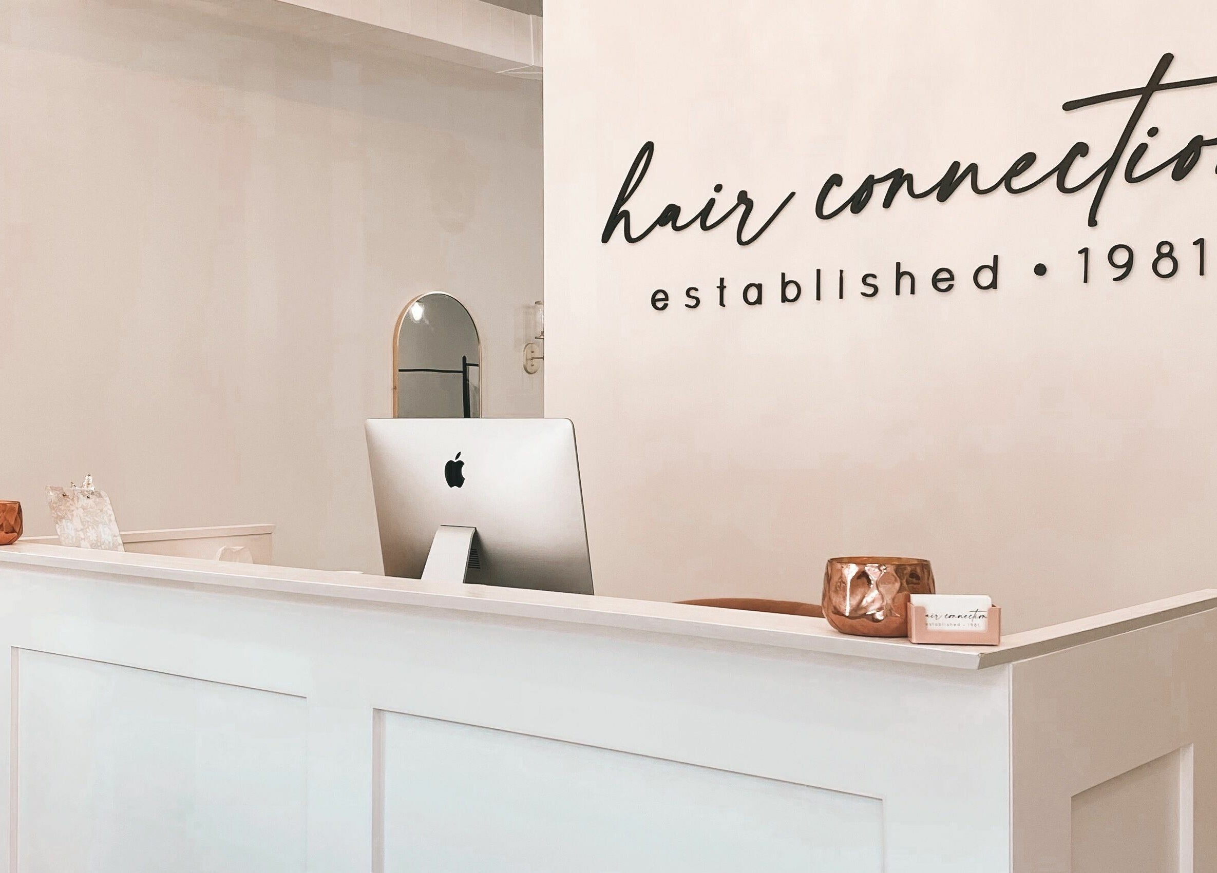 Reception desk at Hair Connection Cambridge, Ontario, CA showcasing modern décor and inviting ambiance.