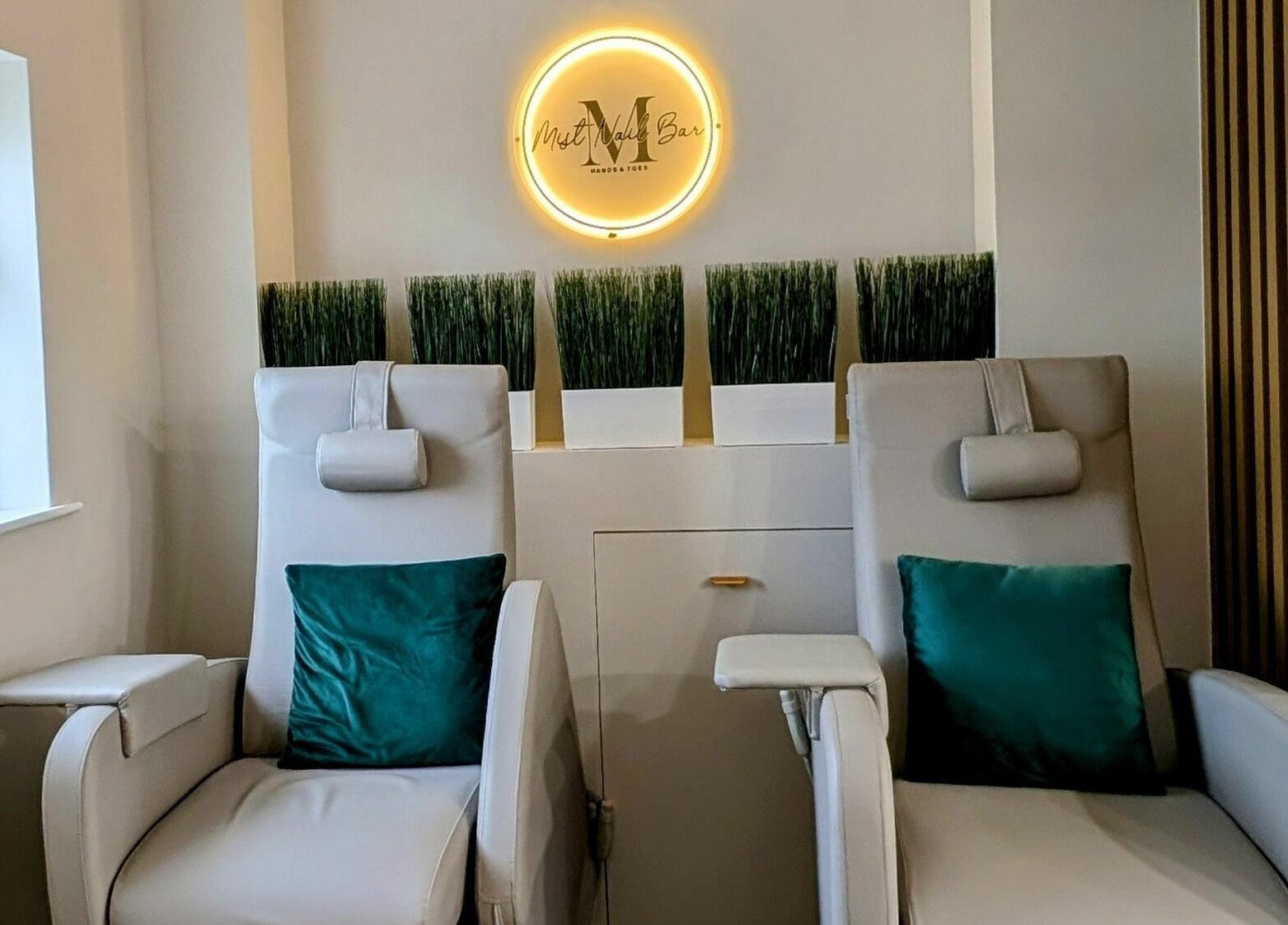 Relaxing seating area at Mist Nail Bar, Carrigaline, County Cork, IE featuring plush chairs and green pillows.
