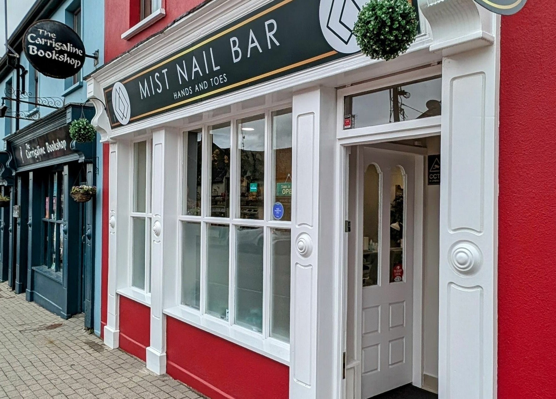 Front of Mist Nail Bar, Carrigaline, County Cork, IE with vibrant red and white exterior.
