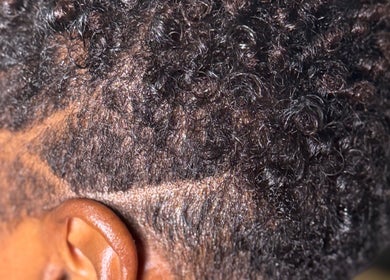 Close-up of a stylishly trimmed curly hairstyle at Nspyre Beauty in Bridgetown, Christ Church, BB.