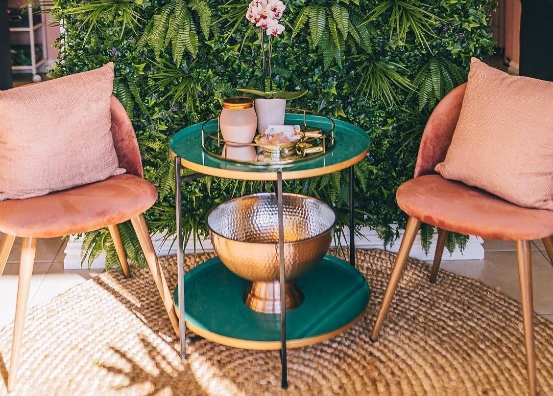 Comfortable seating area at Lola’s Lash Artistry, Westville, KwaZulu-Natal, ZA, with green plants and soft pink chairs.