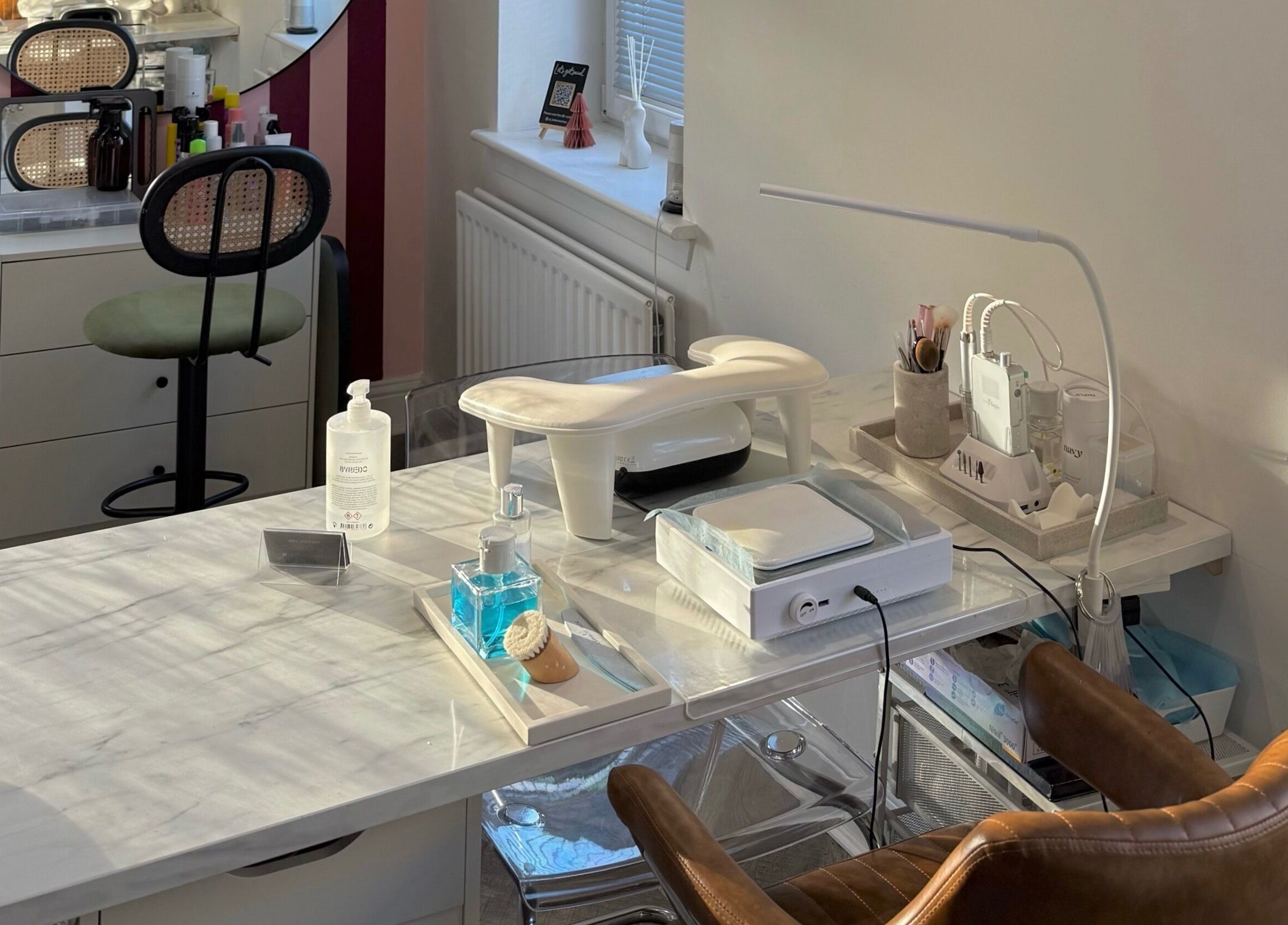 Nail station at Spice and Paint Salon, Bathgate, Scotland, GB featuring modern tools and cozy seating.