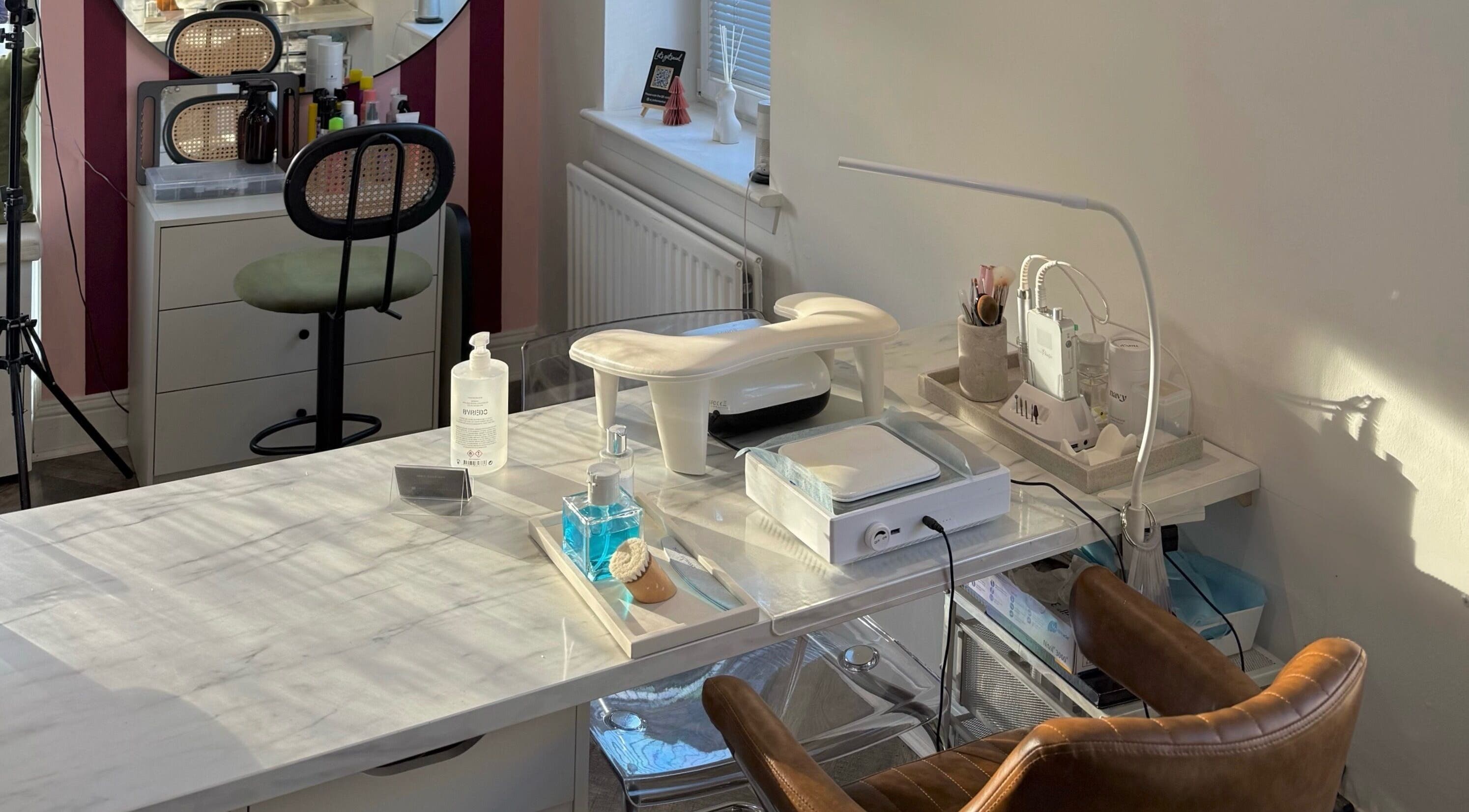 Nail station at Spice and Paint Salon, Bathgate, Scotland, GB featuring modern tools and cozy seating.