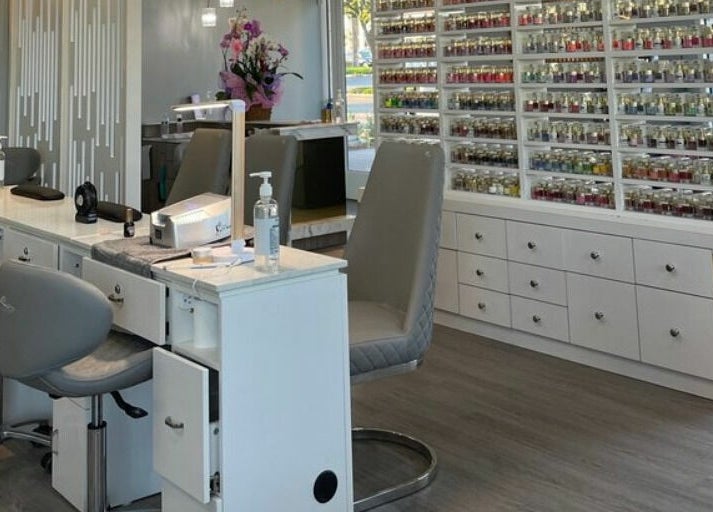 Modern manicure station at Bonjour Nail Bar, Rancho Cucamonga, California, US, showcasing nail polish collection.