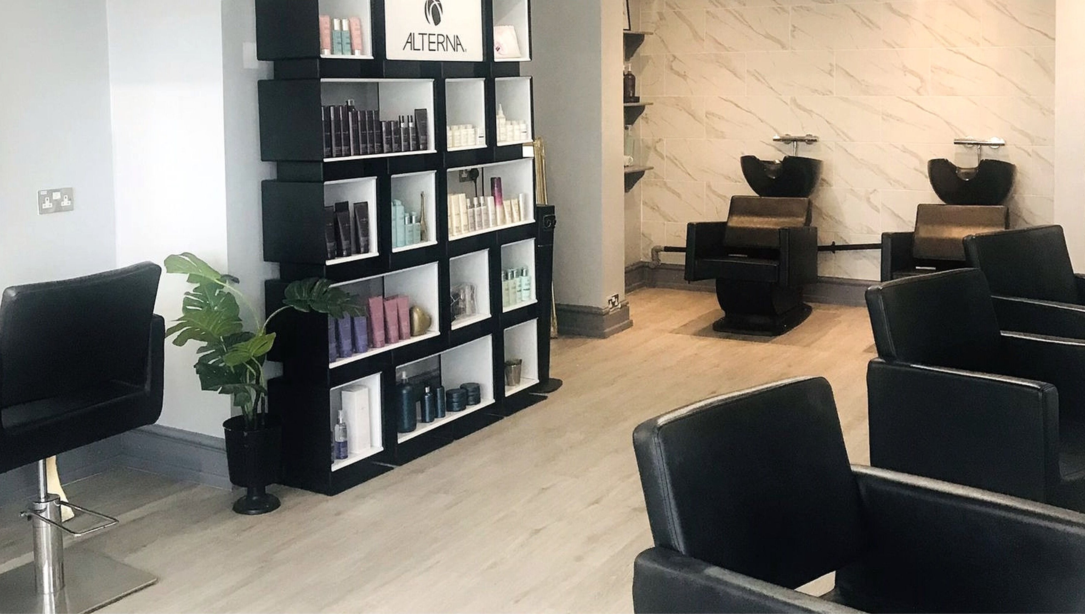 Interior of Lucia Hair in Lostock Hall, England, GB, showcasing sleek styling chairs and modern product display.