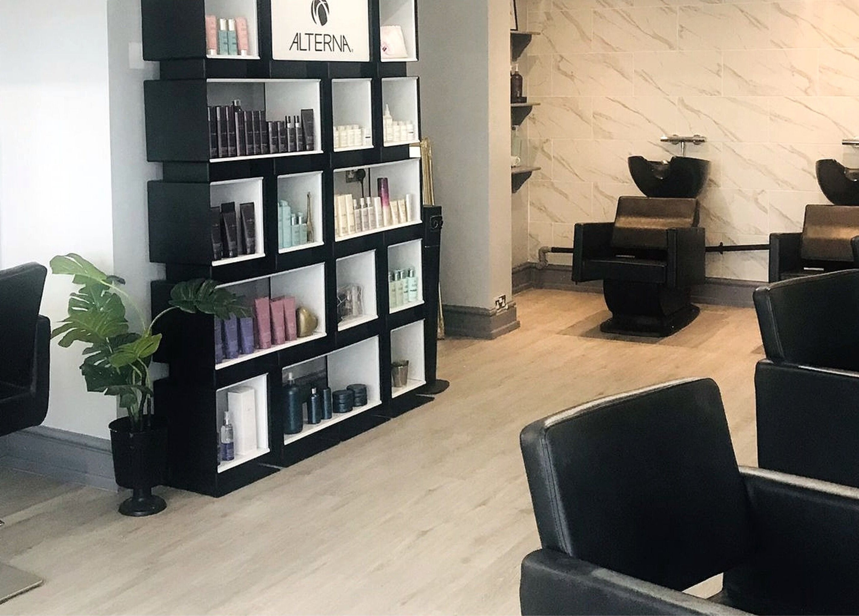 Interior of Lucia Hair in Lostock Hall, England, GB, showcasing sleek styling chairs and modern product display.