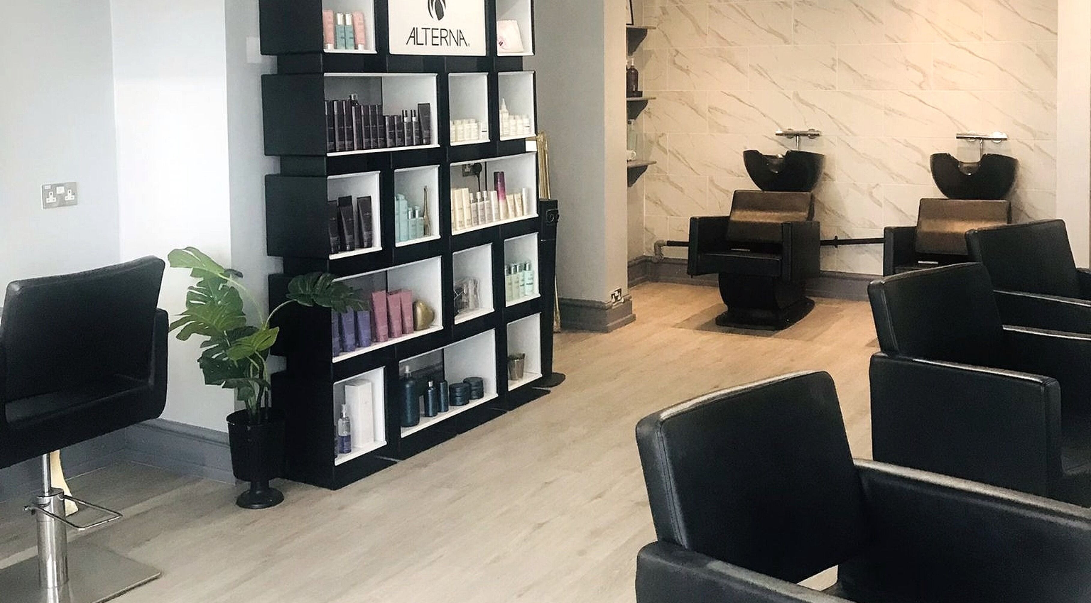 Interior of Lucia Hair in Lostock Hall, England, GB, showcasing sleek styling chairs and modern product display.