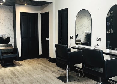 Modern salon interior at Lucia Hair, Lostock Hall, England, GB, featuring sleek chairs and mirrors.