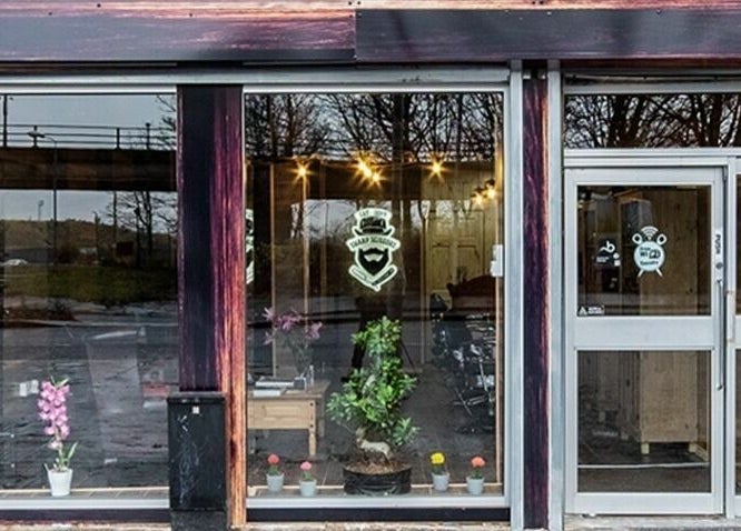 Front view of Sharp Scissors in Glasgow, Scotland, GB with stylish glass doors and inviting interior.