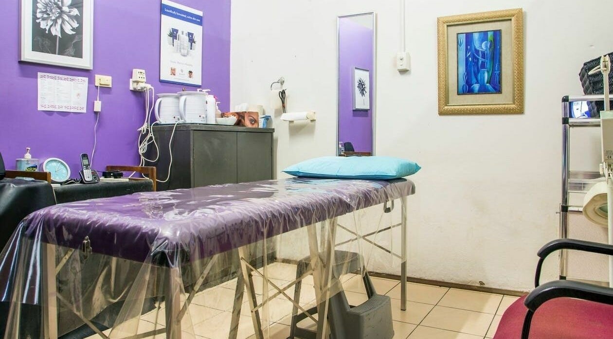 Tranquil waxing room at Just Wax It, Seaton, South Australia with purple walls and a treatment bed.
