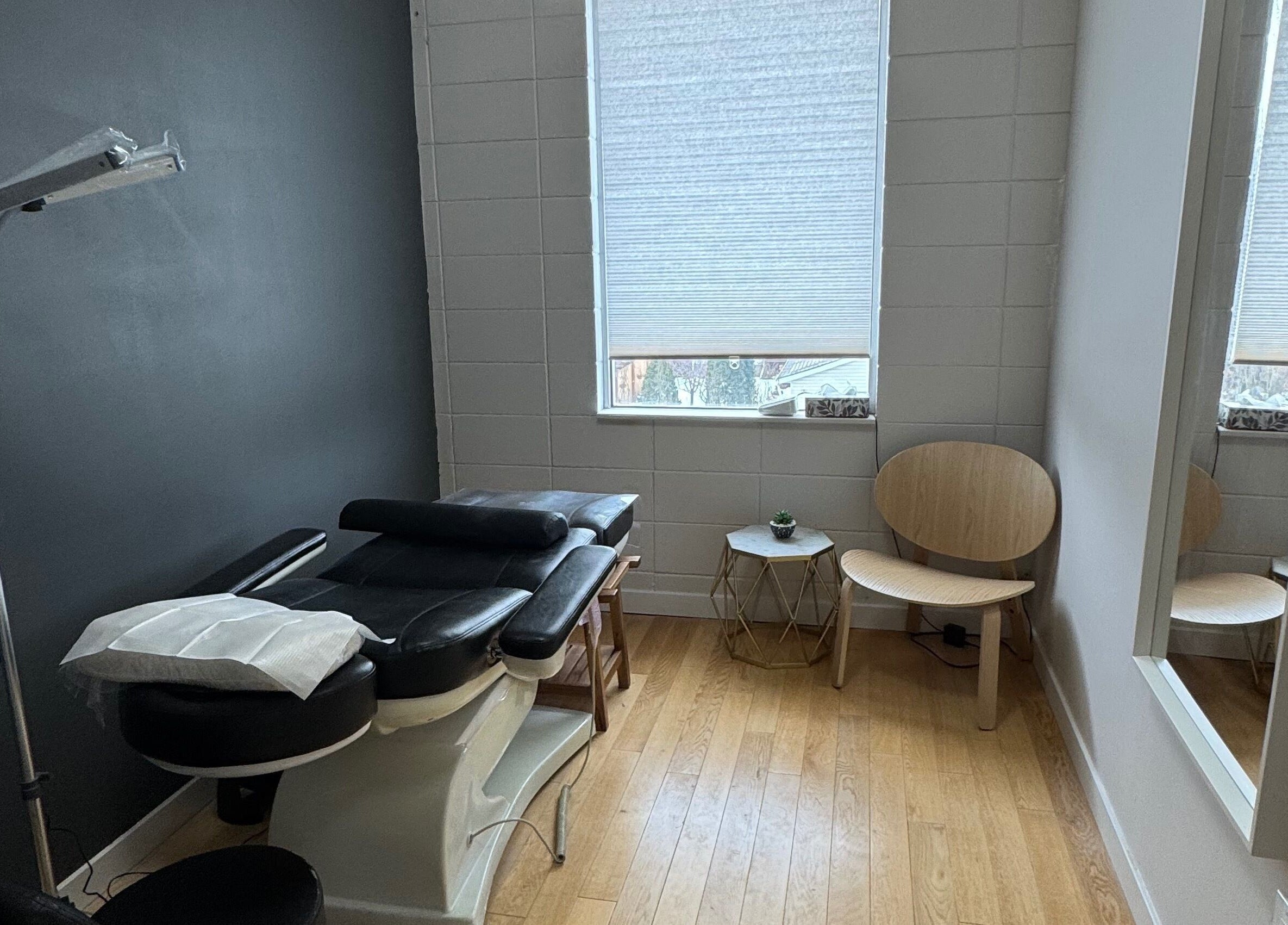Massage room at JPMU by Palette, Edmonton, Alberta, CA with black massage table and modern decor.