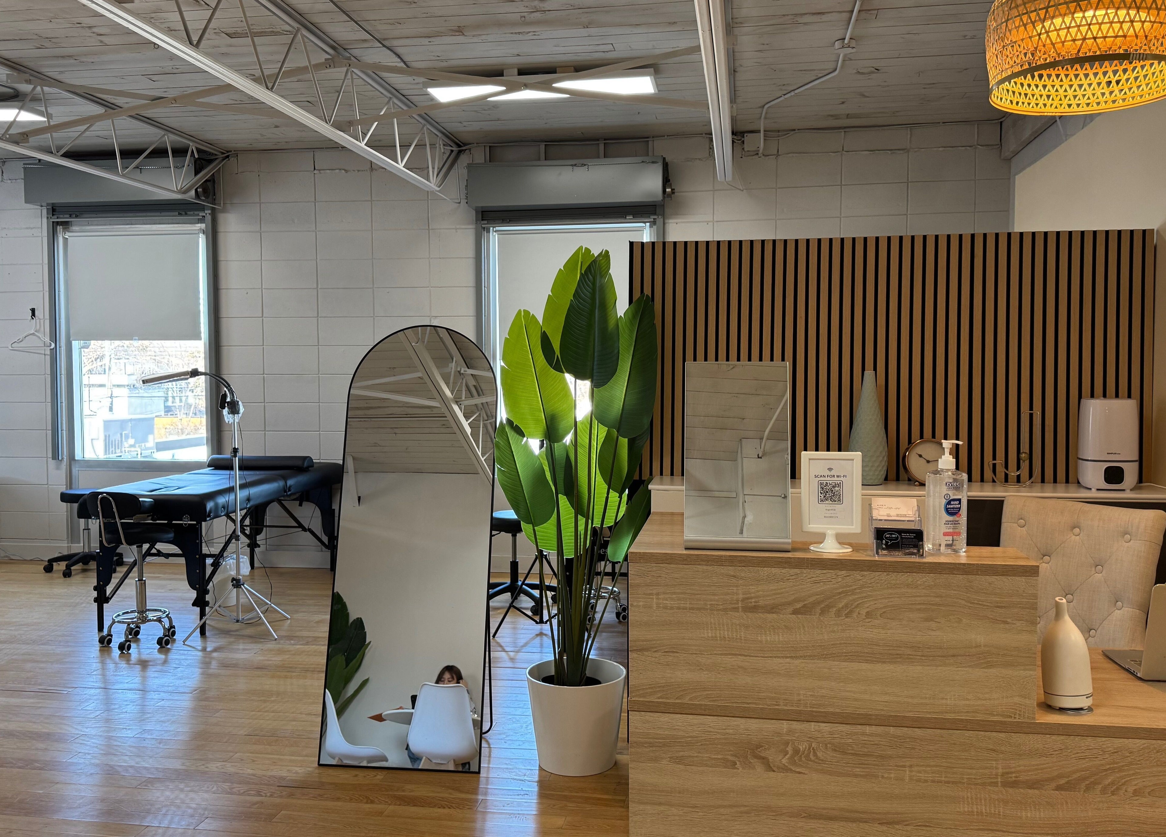Modern treatment room at JPMU by Palette, Edmonton, Alberta, CA. Stylish decor with mirrors and wooden accents.