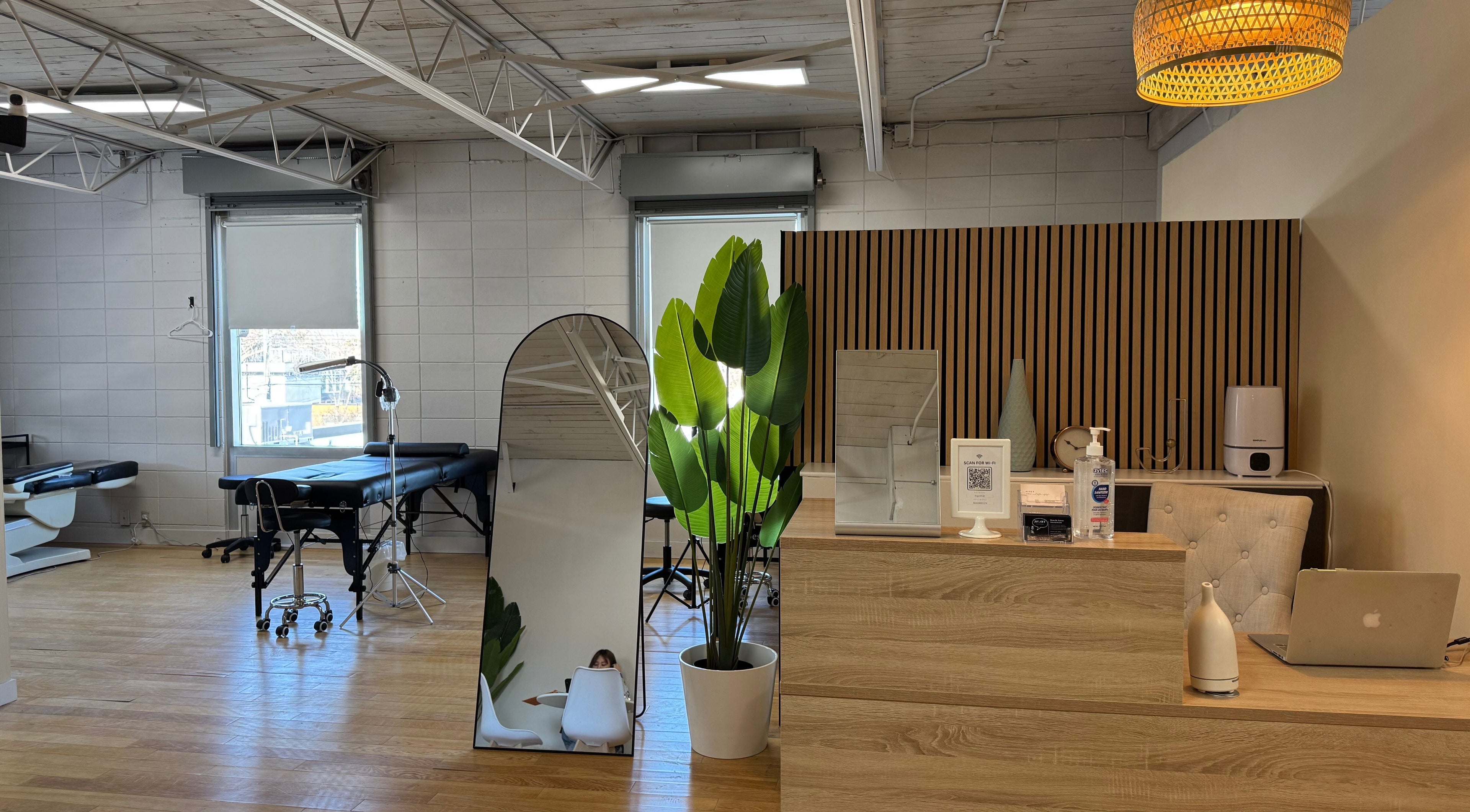Modern treatment room at JPMU by Palette, Edmonton, Alberta, CA. Stylish decor with mirrors and wooden accents.