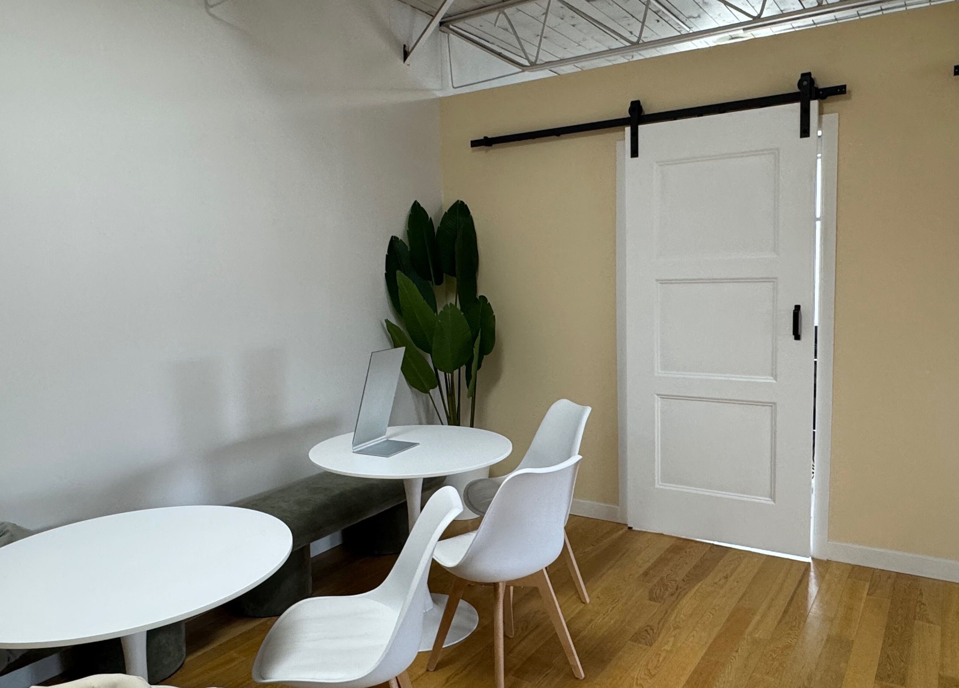 Modern seating area at JPMU by Palette, Edmonton, Alberta, CA, with white chairs and a round table.