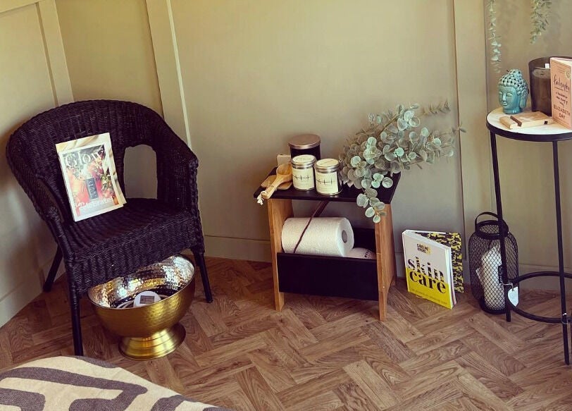 Inviting cozy corner at Dollface Beauty by Beth, Lostock Hall, England, GB, with chair, decor, and skincare books.