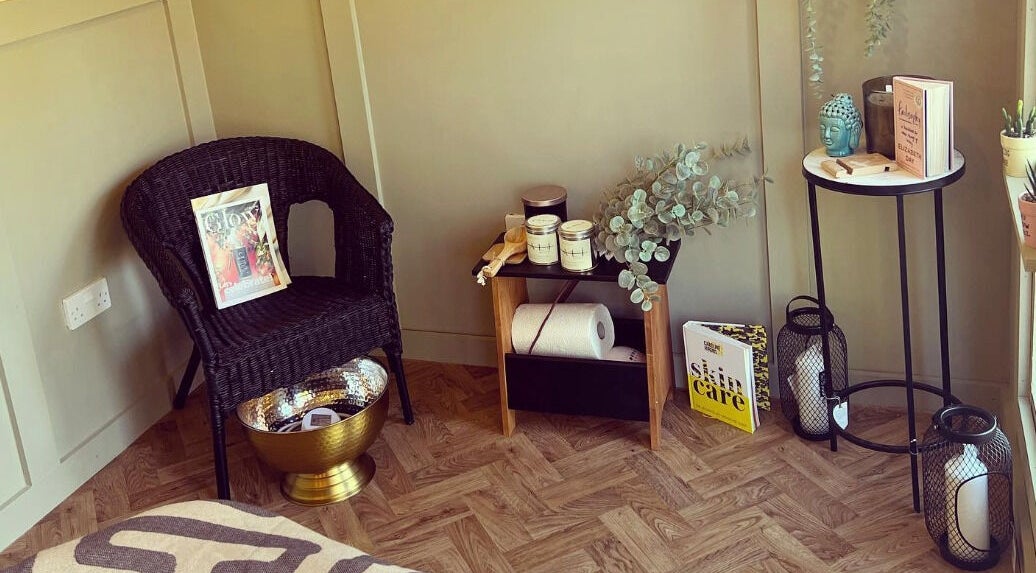Inviting cozy corner at Dollface Beauty by Beth, Lostock Hall, England, GB, with chair, decor, and skincare books.