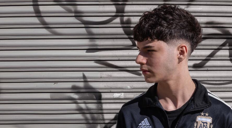 Joven con corte de cabello moderno frente a un fondo urbano en BH Estudio, Piñeyro, Provincia De Buenos Aires, AR.