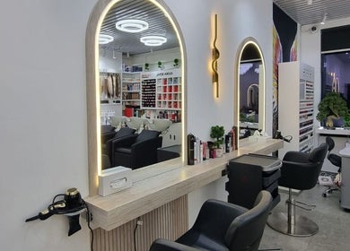 Modern salon interior at Mike and Kals, Dubai, AE, featuring chic mirrors and styling chairs.