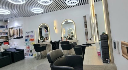 Modern interior of Mike and Kals salon in Dubai, AE, showcasing stylish black chairs and illuminated mirrors.