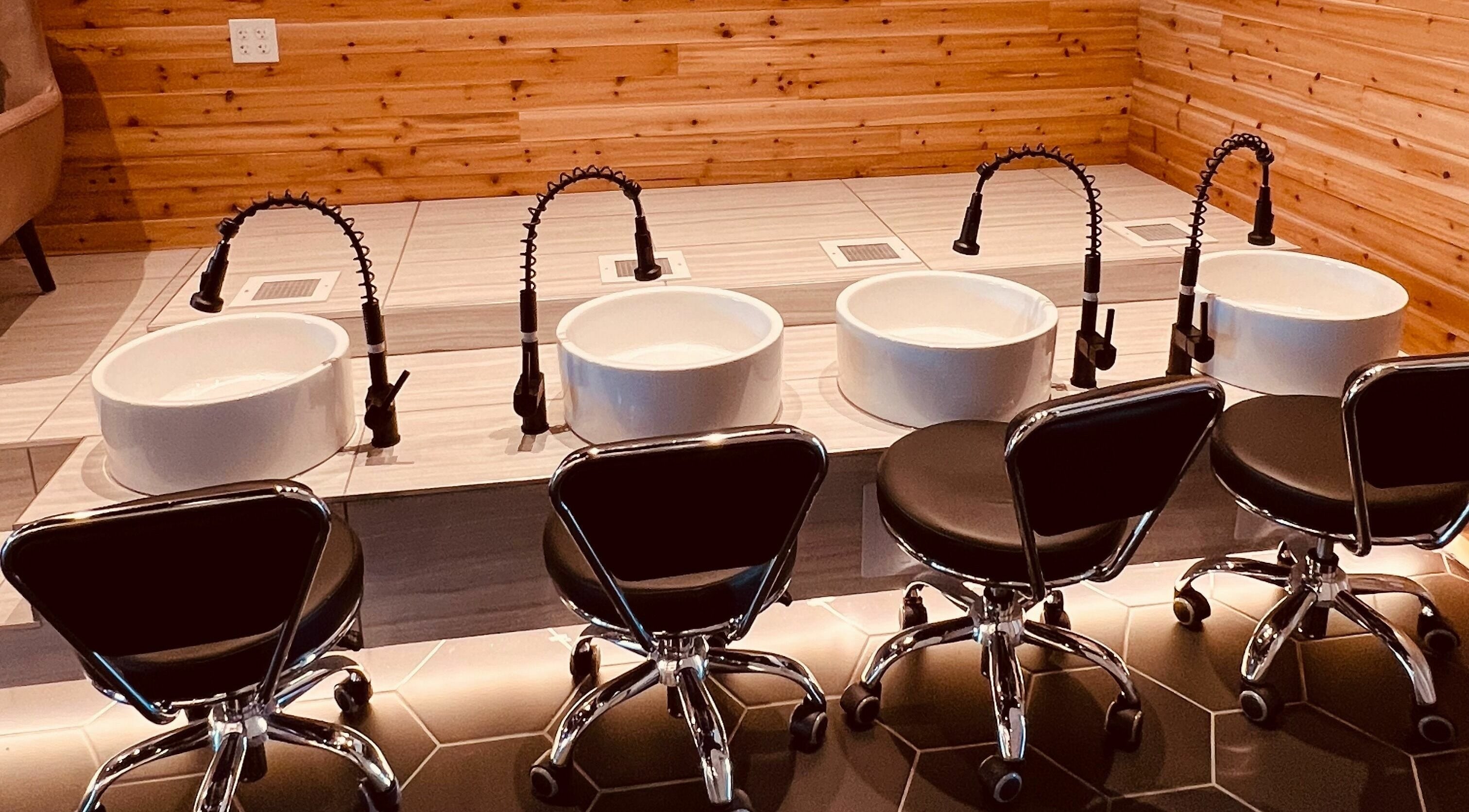 Modern pedicure stations at Bennington Nail Bar, Bennington, Nebraska, US, with stylish black chairs.