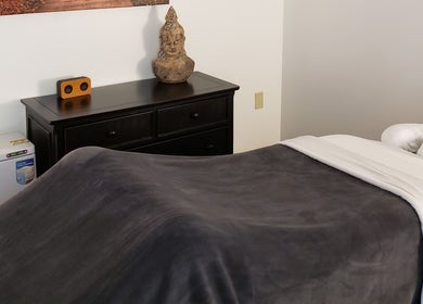 Peaceful massage room at Clinical Elements, Loveland, Ohio, US, with a Buddha statue and cozy setting.