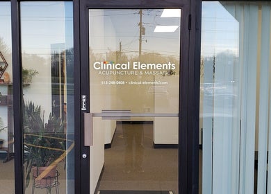 Front entrance of Clinical Elements in Loveland, Ohio, US, featuring glass doors and decorative plants.
