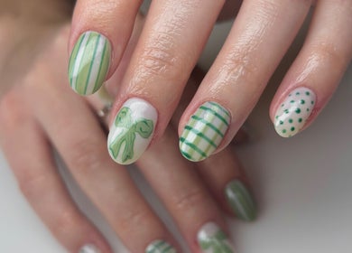 Stylish green nail art at The Nail Garden, Lansing, Michigan, US. Perfect blend of stripes, dots, and bow designs.