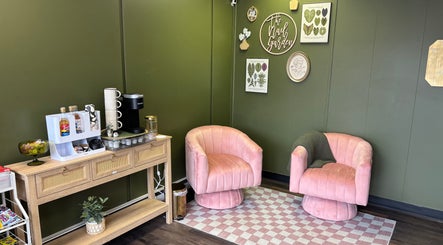 Chic waiting area at The Nail Garden, Lansing, Michigan with pink chairs and beverage station.