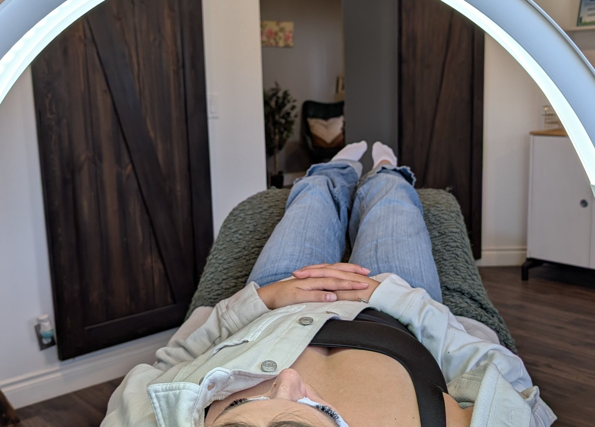 Client relaxing under LED light therapy at Claire'ity Care in Blackfalds, Alberta, CA.